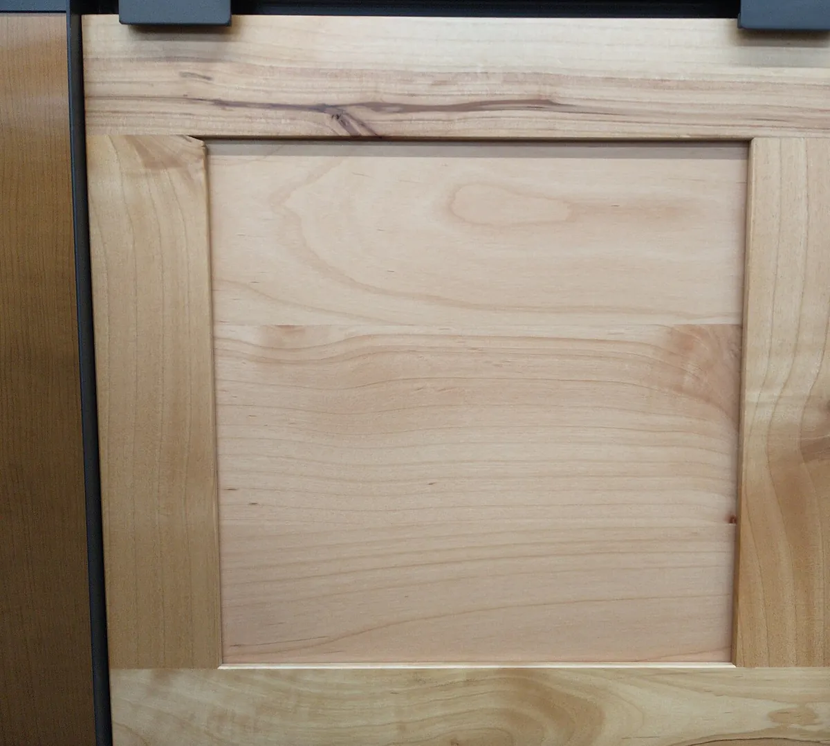 A light maple shaker cabinet door showing the frame and flat centre panel
