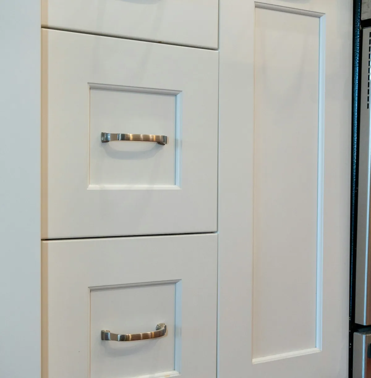 Cabinet fronts with consistent reveals and matched hardware, the visible result of a specified job