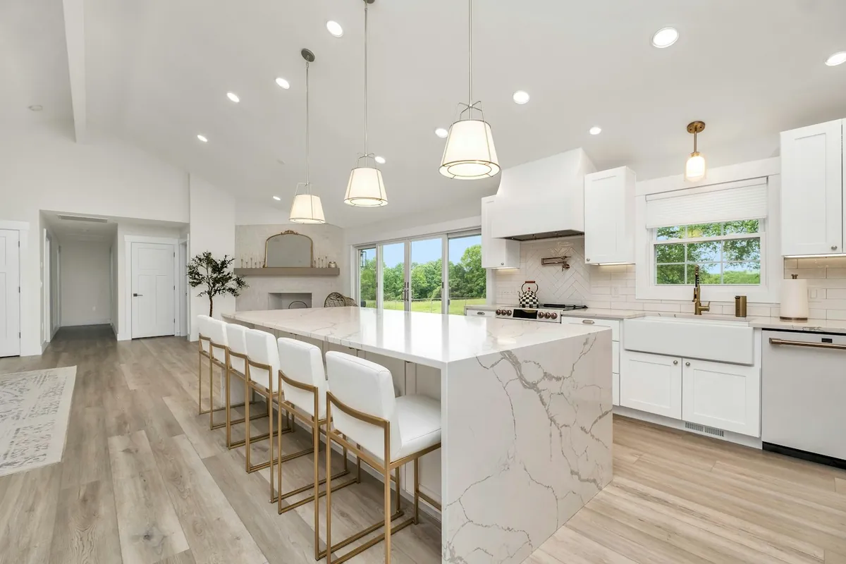 White shaker kitchen cabinets and a marble waterfall island in a Huntington Beach CA home