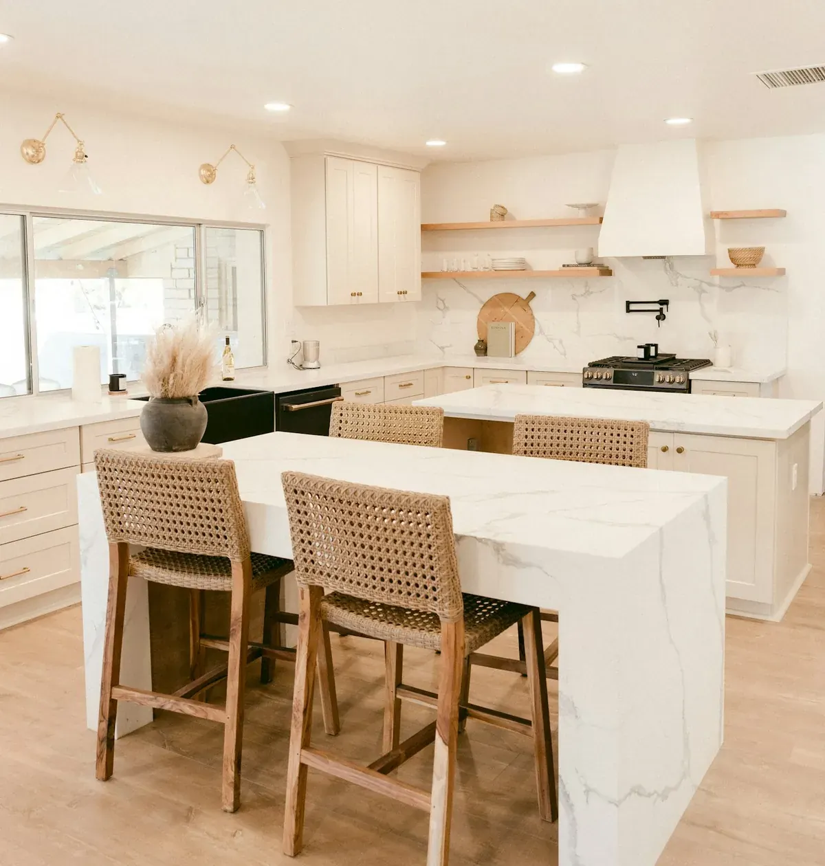 A coastal Californian kitchen with cream cabinets, brass hardware and marble islands, typical of Newport Beach CA specification