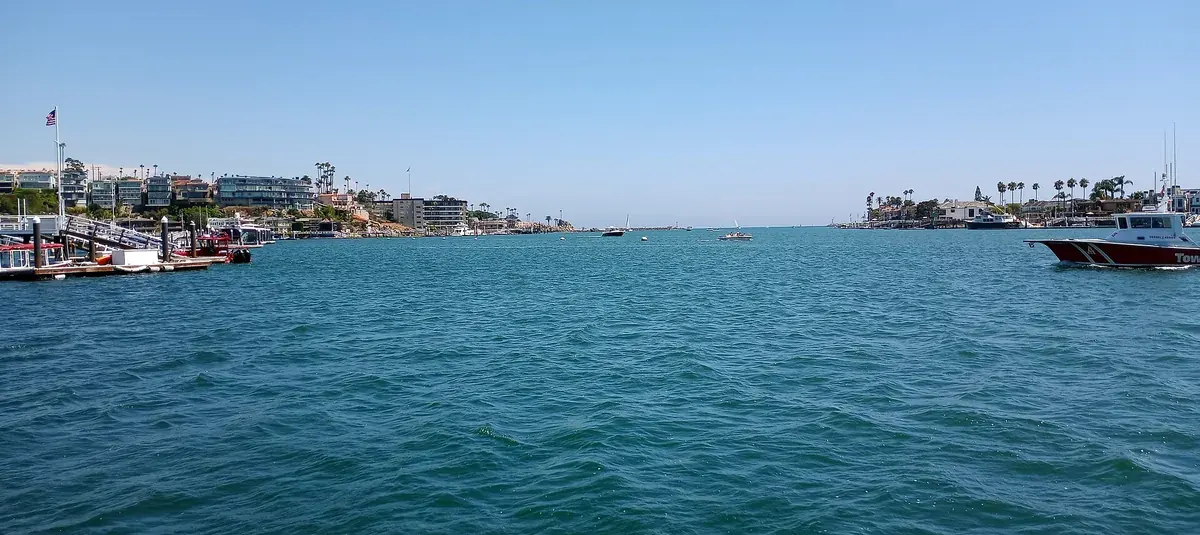 The entrance to Newport Harbor in Newport Beach CA with waterfront houses on both headlands