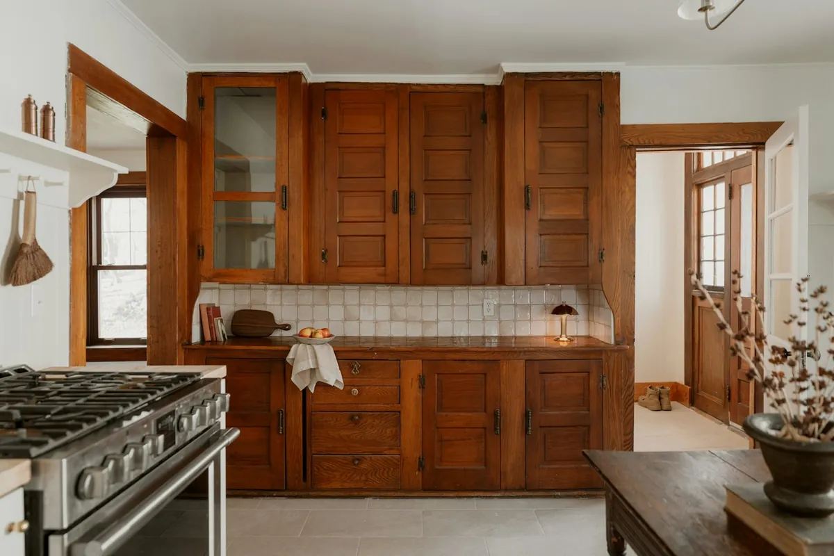 Original stained wood built-in cabinets with a glass front door in an older California kitchen